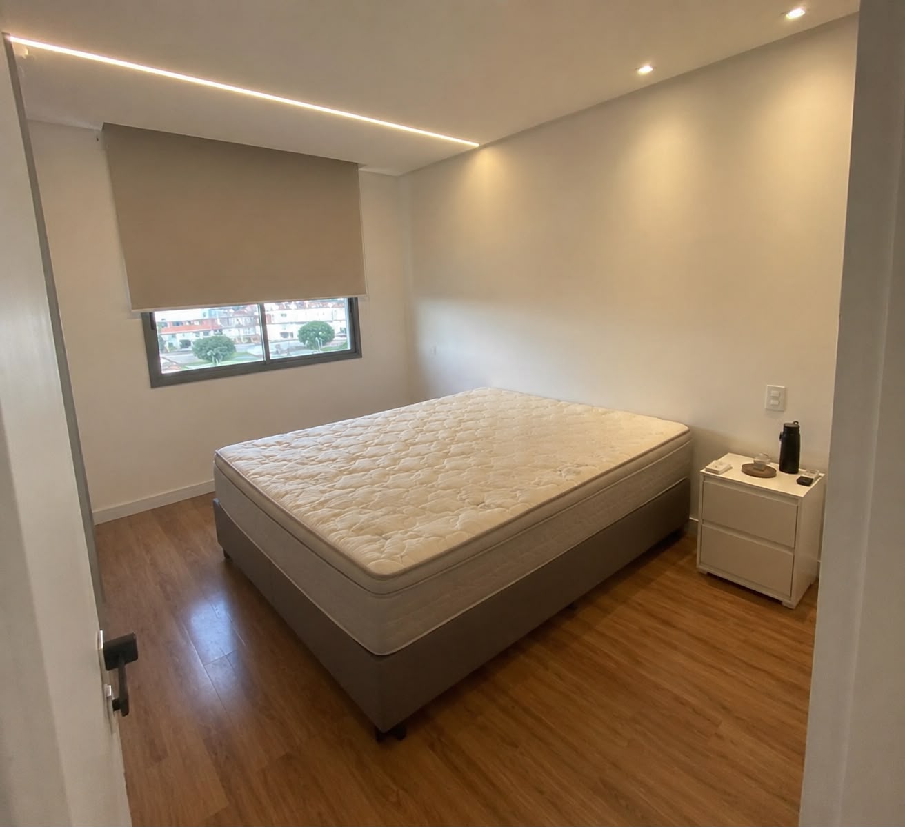 Quarto antes da consultoria, com cama sem cabeceira e paredes vazias